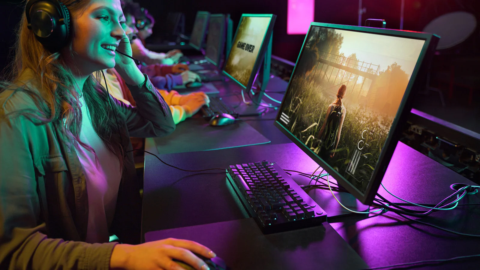 Mujer usando auriculares y trabajando en edición de video o gaming en un ordenador.